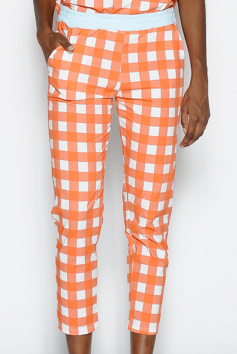 Pantalón P A N producto básico en cuadros blanco y naranja, y cintura en azul claro.