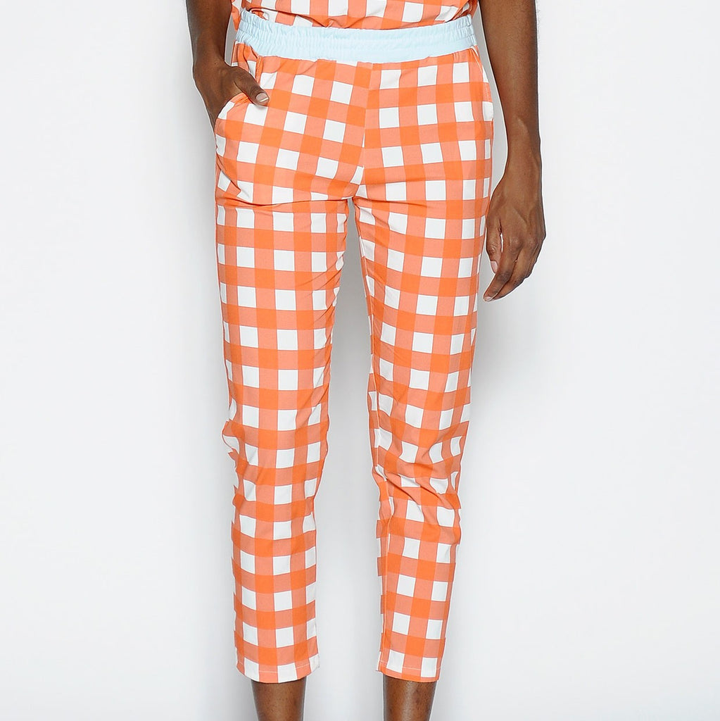 Pantalón P A N producto básico en cuadros blanco y naranja, y cintura en azul claro.